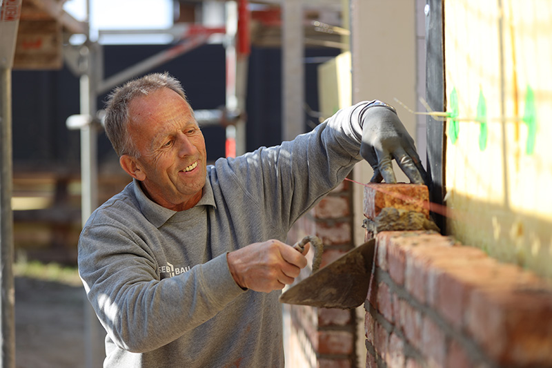 Eine junge Familie sitzt gemeinsam im Wohnzimmer